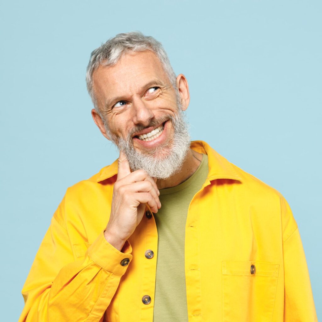 Elderly happy wistful minded gray-haired mustache bearded man 50s wearing yellow shirt