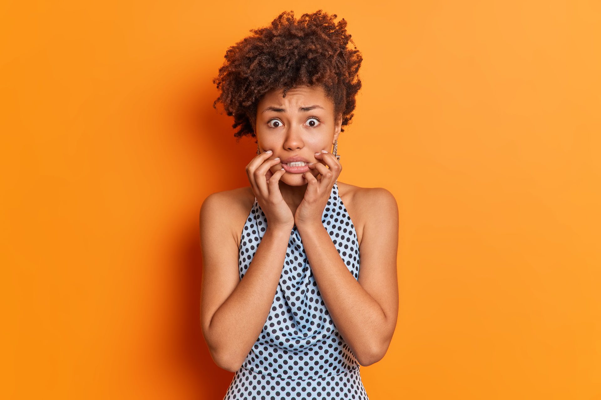 Nervous worried woman clenches teeth looks embarrassed