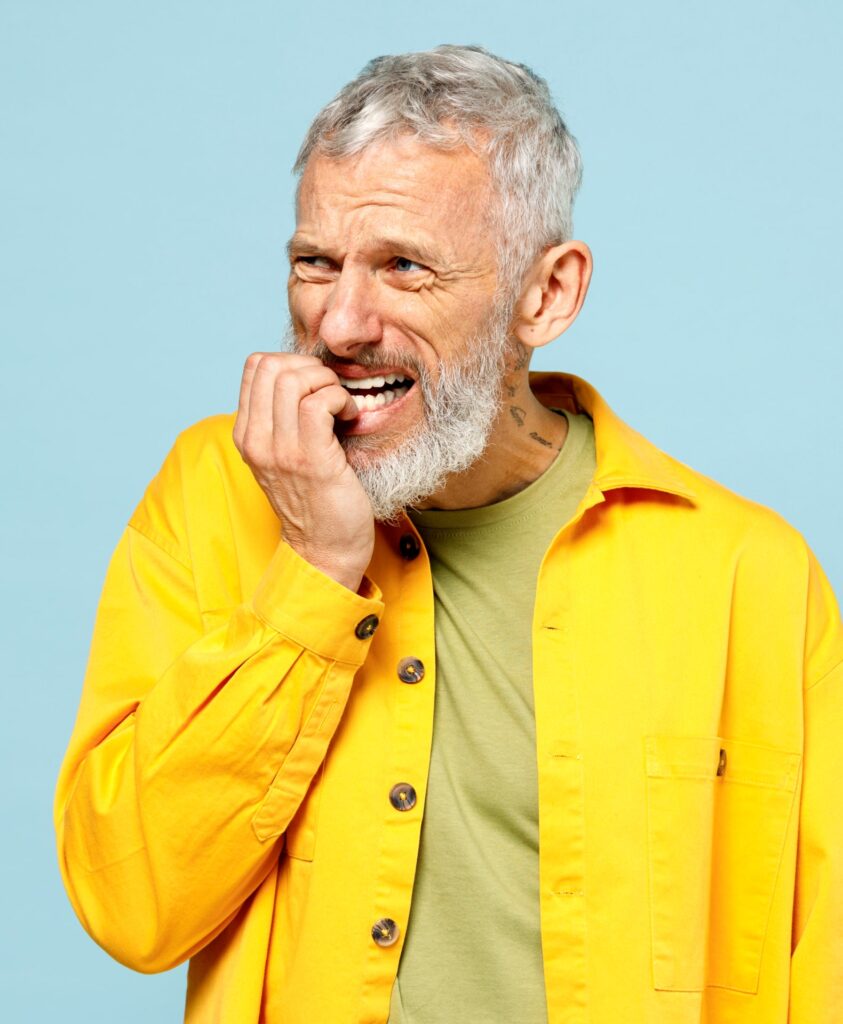 Elderly gray-haired man biting nails